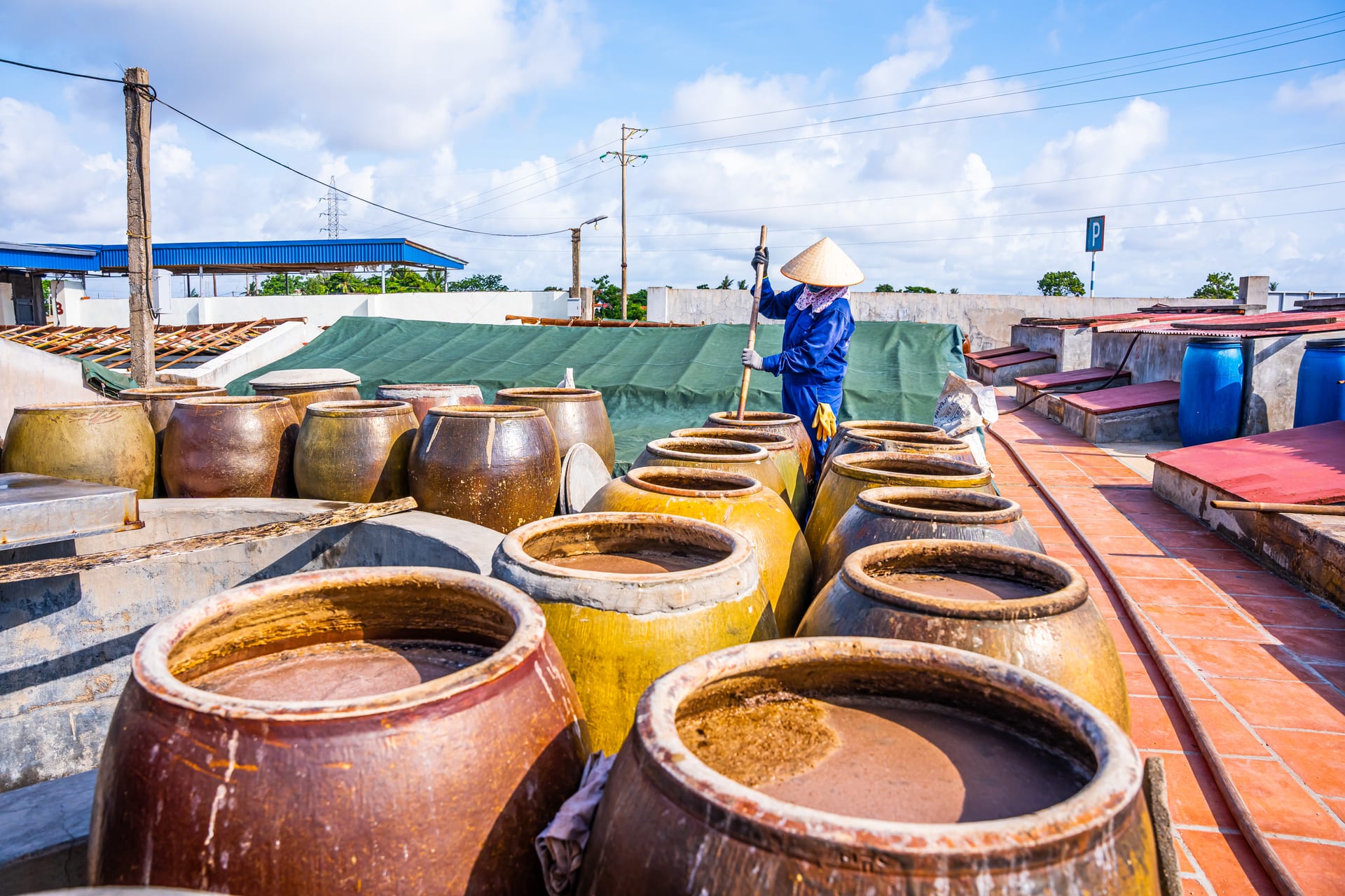 Công nhân đánh quậy chượp giữa sân chum tại Cát Hải