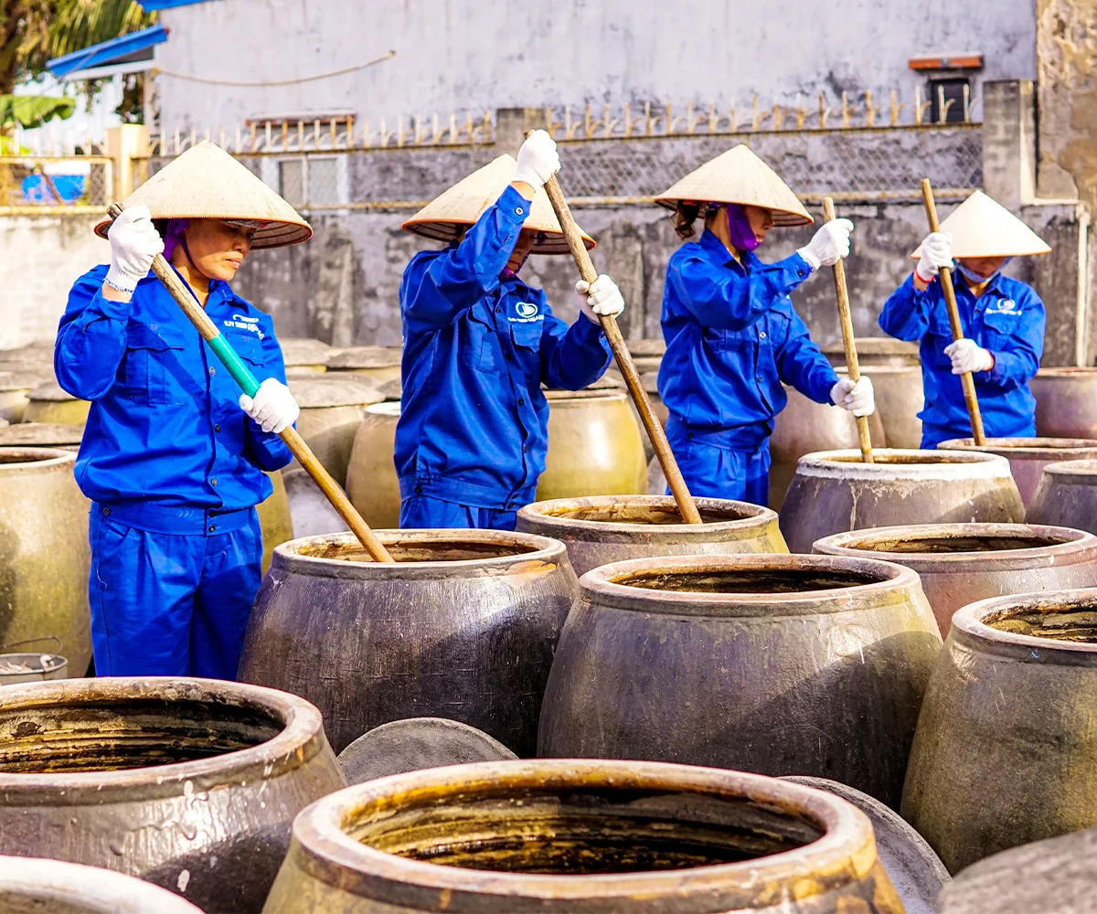 Công nhân Quang Hải đánh đảo chượp trong chum ủ nước mắm tại Cát Hải