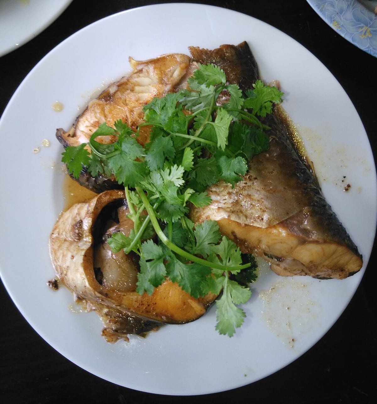 Khúc cá kho bày đĩa với rau mùi